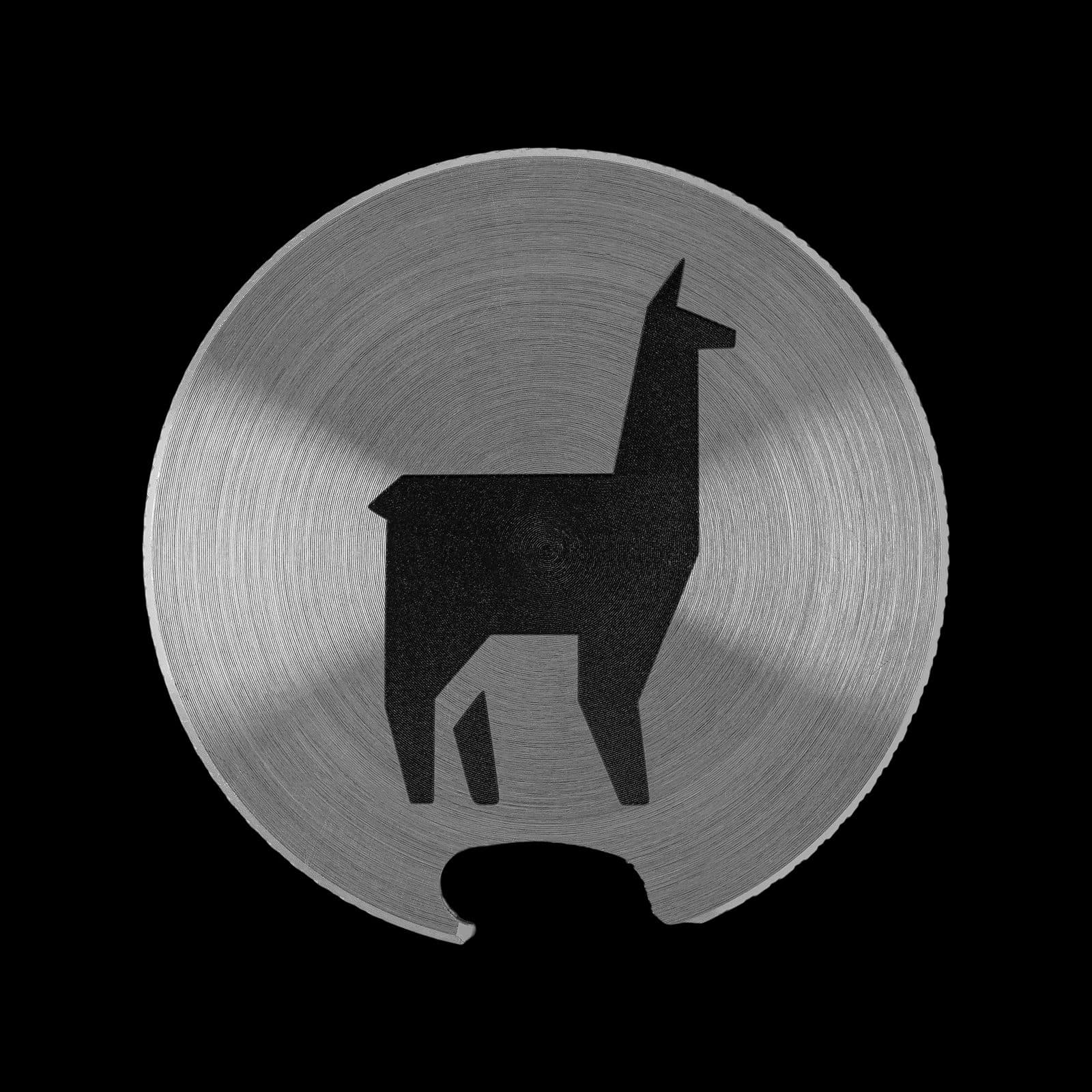Round brushed stainless steel bottle opener engraved with a black geometric llama silhouette logo.